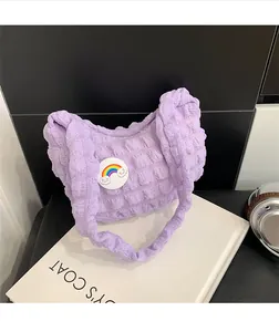 Détail du sac nuage plissé lilas avec badge arc-en-ciel et texture en tissu bulle doux
