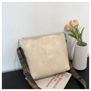 Detail of off-white tote bag featuring a wide bohemian patterned fabric shoulder strap