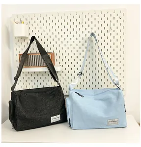 Close-up of black and blue large canvas pillow bags with adjustable straps on a shelf