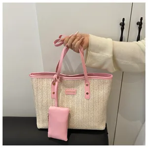 Detail of straw tote bag with pink PU leather trim and a small matching pouch