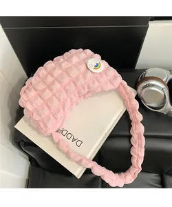 Détail du sac nuage plissé rose avec un badge arc-en-ciel et une bandoulière froncée