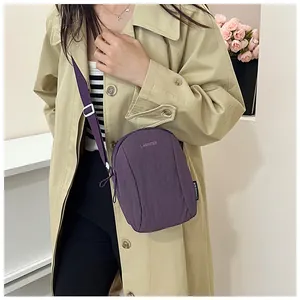 Deep purple nylon crossbody bag detail with adjustable strap and front zipper pocket