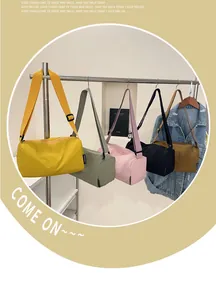 Detail of colorful nylon cylinder crossbody bags with adjustable straps and zip closure