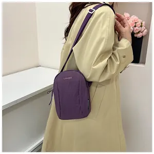 Detail of purple waterproof nylon crossbody bag with adjustable strap and brand embroidery