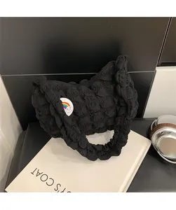 Détail du sac nuage noir plissé avec écusson arc-en-ciel et fermeture éclair
