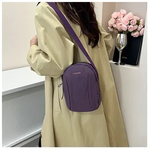 Purple nylon crossbody bag featuring stylish LANWEIER embroidery on a model in a trench coat