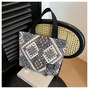 Detailed shot of ethnic embroidered tote bag with geometric patterns on a wooden chair
