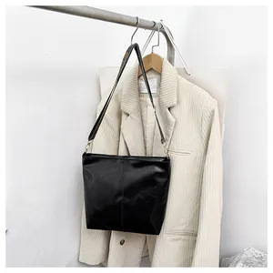 Close-up of vintage black tote bag with wrinkled texture and gold metal ring details