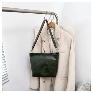 Close-up of vintage oil wax leather tote bag with ethnic geometric pattern wide strap