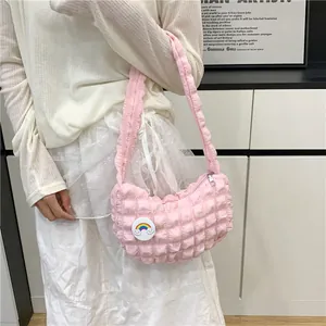 Sac nuage rose avec breloque arc-en-ciel et texture plissée porté par un mannequin