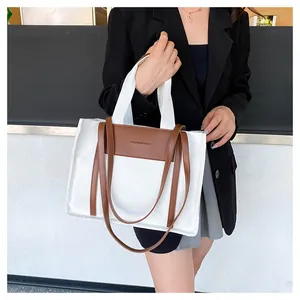 Detail of canvas tote bag with brown leather trim and dual strap fashion design