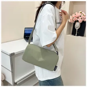 Light green nylon crossbody pillow bag with wide strap and brand label detail