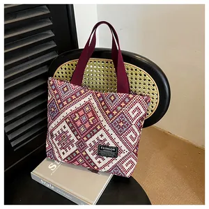 Detailed view of ethnic jacquard tote bag with geometric patterns on a black rattan chair