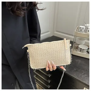 Gros plan du sac tissé beige avec bordure de perles argentées et chaîne en métal