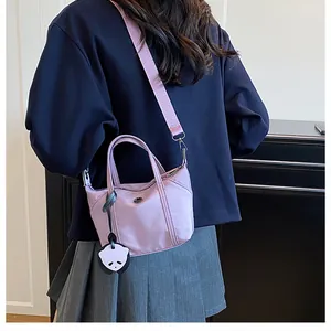 Lavender nylon mini tote bag with panda pendant and adjustable strap on a model