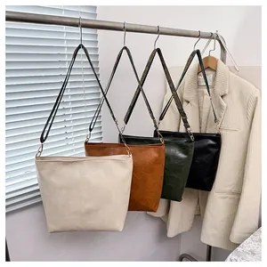 Detail view of four large retro hobo bags with geometric pattern wide straps in various colors