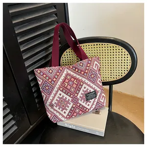 Detailed view of ethnic woven tote bag with geometric patterns and canvas shoulder straps