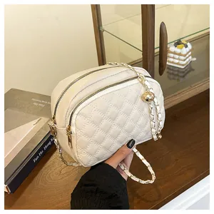 Vista laterale del sacchetto beige trapuntato con catena dorata e doppia zip