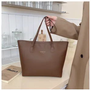Vista detallada de bolso tote de cuero marrón oscuro con letras doradas fashion bag NEW YORK