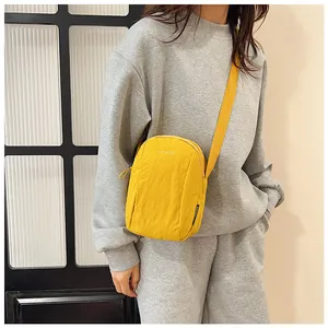 Detail of a bright yellow waterproof nylon crossbody bag with adjustable shoulder strap