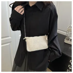 Détail du sac bandoulière tissé crème avec bordure en perles et chaîne en métal