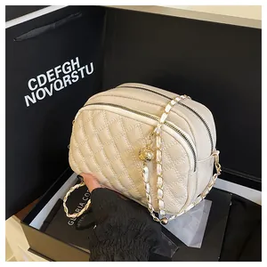 Dettaglio borsa trapuntata beige in pelle con catena e sfera dorata regolabile da donna
