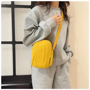 Detailed view of yellow nylon crossbody bag on model with adjustable strap for commuting