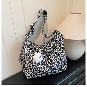 Détail du sac fourre-tout en toile léopard avec fermeture éclair et breloque en peluche