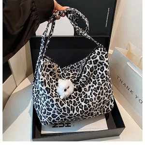 Détail d'un grand sac cabas léopard avec bandoulière large et pendentif peluche