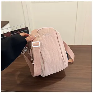 Close-up of light pink nylon cross-body bag featuring white LANWEIER letter embroidery