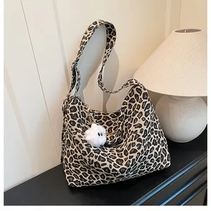 Détail du sac cabas léopard en toile avec bandoulière réglable et charme en peluche