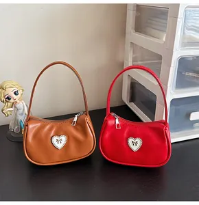Detailansicht der glatten PU-Handtaschen mit Herz-Diamant-Dekor und Schleifen