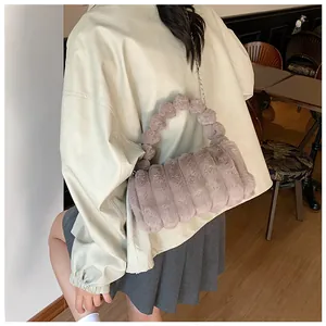 Détail du sac à main en peluche violet clair avec poignée pompon et chaîne en métal
