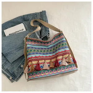 Detail of bohemian woven bag with colorful geometric patterns and decorative tassels