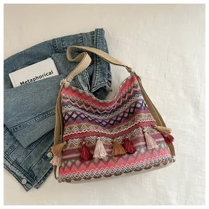 Close-up of bohemian woven shoulder bag with colorful stripes and tassel details