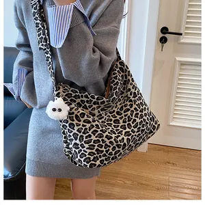 Détail du sac cabas en toile léopard avec large bandoulière et pendentif en peluche