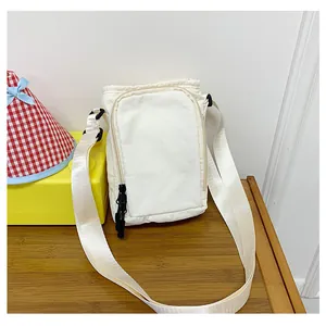 Λεπτομέρεια κρεμ νάιλον τσάντας χιαστί με διπλά φερμουάρ και φαρδύ ιμάντα ώμου