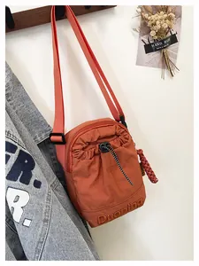 Vue détaillée du sac bandoulière en nylon orange avec broderie Duoning et cordon
