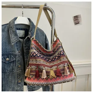Detailed view of colorful ethnic woven tote bag with vibrant tassels and wave patterns