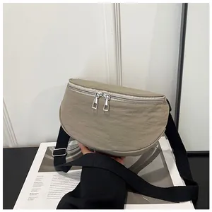 Macro detail of khaki crescent bag featuring durable wrinkled fabric and silver zippers