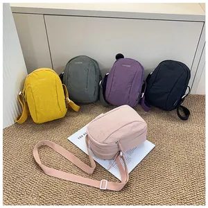 Detailed array of multi-colored waterproof nylon crossbody bags with adjustable straps