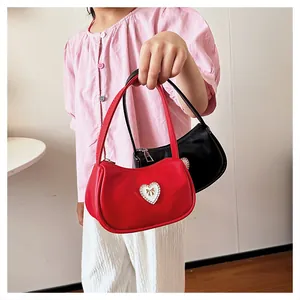 Detailaufnahme der Mädchen-Minihandtaschen mit Herz-Abzeichen in Rot und Schwarz