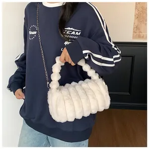 Détail du sac bandoulière en peluche blanche avec design à niveaux et chaîne argentée