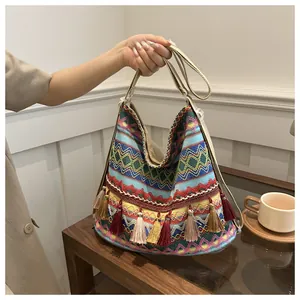 Detail of bohemian woven hobo bag with colorful wave patterns and fringe tassels