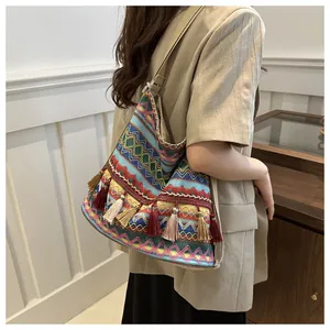 Detailed view of bohemian woven tote bag with colorful geometric patterns and long fringes