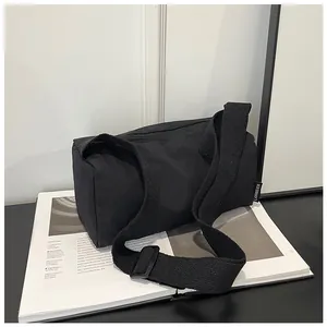 Detail of black nylon cylinder bag showing branded side label and textured fabric surface