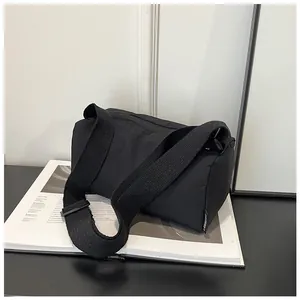Detail of black nylon boston bag with adjustable shoulder strap and woven label on side