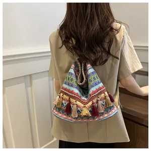 Detail of bohemian backpack featuring colorful woven geometric patterns and vibrant tassels