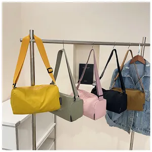Detailed display of cylinder nylon sports bags in five colors on a metal hanger