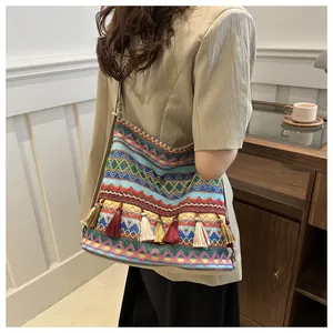 Detail showing the colorful woven texture and tassel decoration of the ethnic shoulder bag